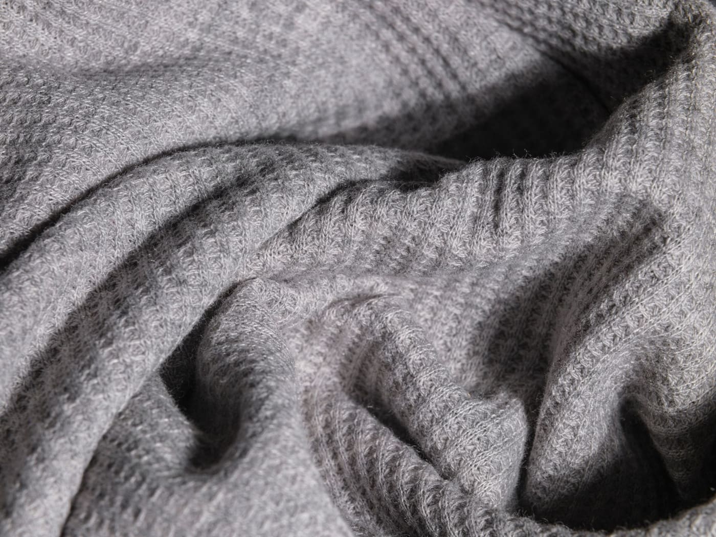 Close-up of soft grey knitted fabric showing the weave